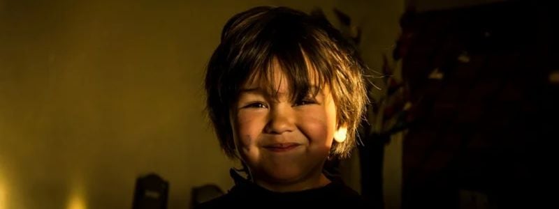 A smiling boy with dirt on his face.