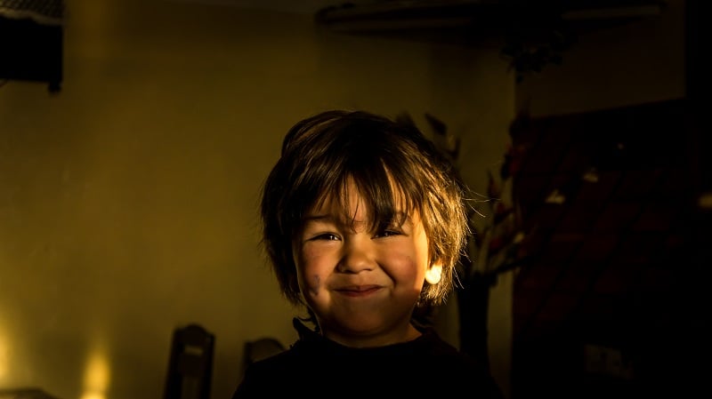 A happy boy with dirt on his face.