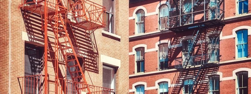 A set of NYC buildings with fire escapes.