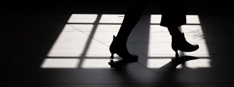 A woman walking in a dark cell.