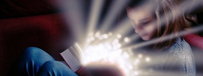 A girl reading a magical book.