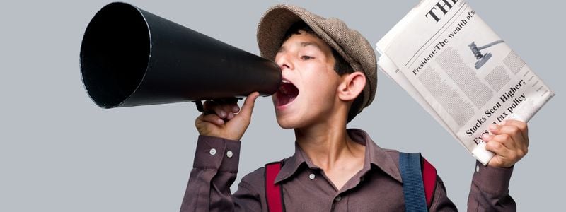 A boy with a newspaper and a megaphone.