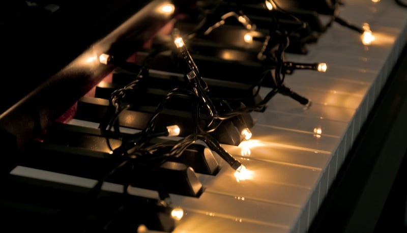 A piano with Christmas lights.