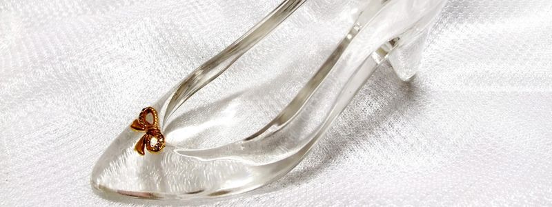 A glass slipper on a white floor.