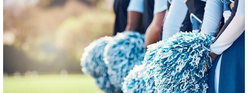 A closeup of cheerleader pompoms outdoors.