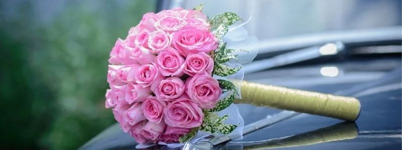 A wedding bouquet on a car.