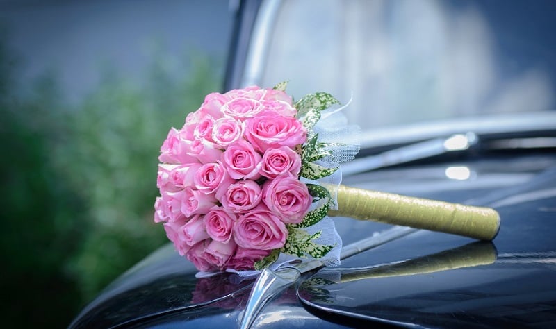 A wedding bouquet on a car.