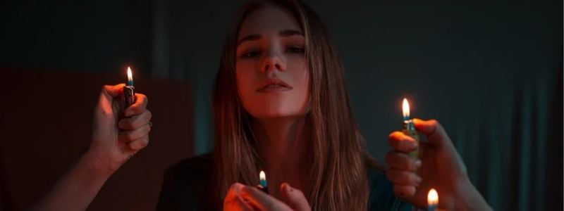 A girl with lit candles around her.