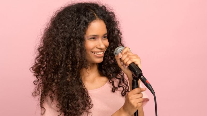A woman singing with a microphone.