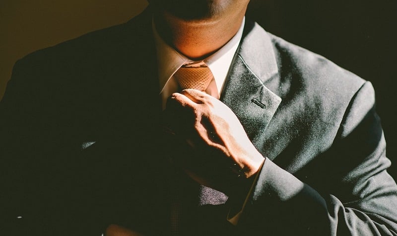 A man fixing his tie.