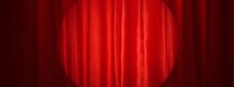 Red stage curtain with spotlight.