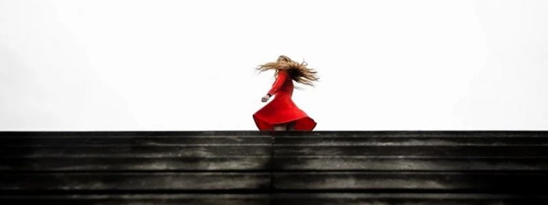 A woman in a red dress twirling.