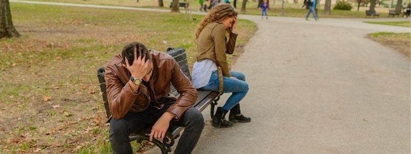 A couple having a disagreement on a bench.