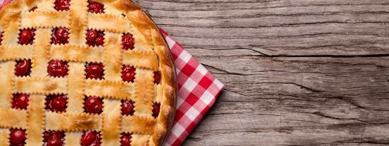 A cherry pie on a checkered napkin.