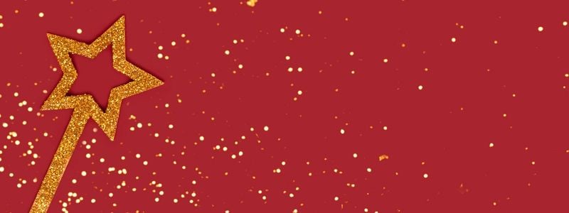A gold magic wand on a red background.