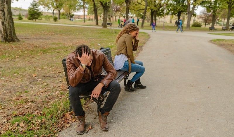 A couple breaking up on a bench.