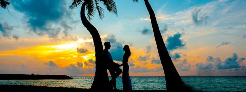 A silhouette of a couple on an island.