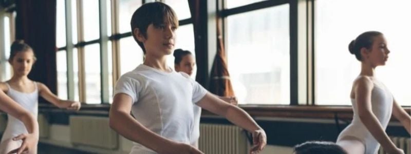 A boy ballet dancer in class.