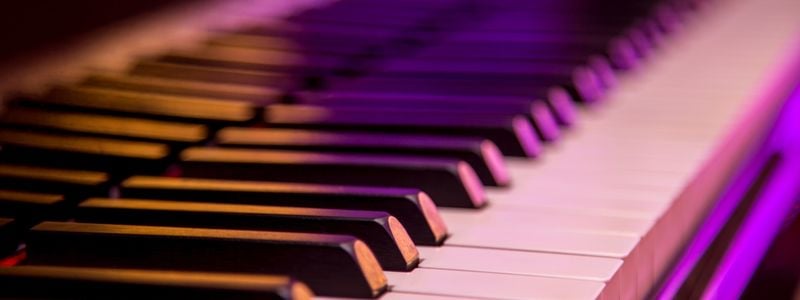 Neon pink and orange lit piano keys.