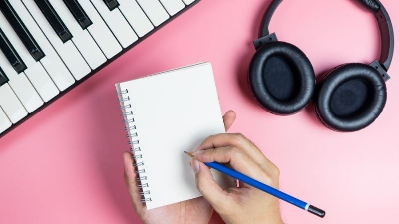Headphones, keyboard, and a notepad.