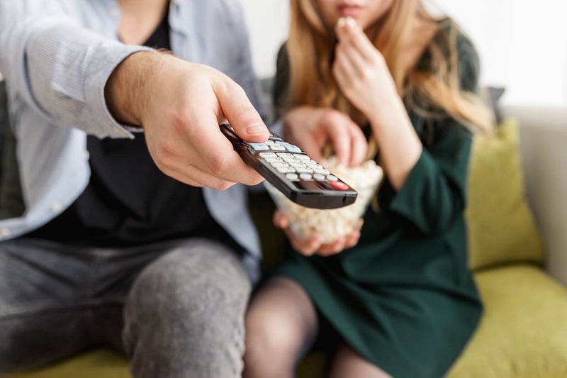 A couple watching TV together.