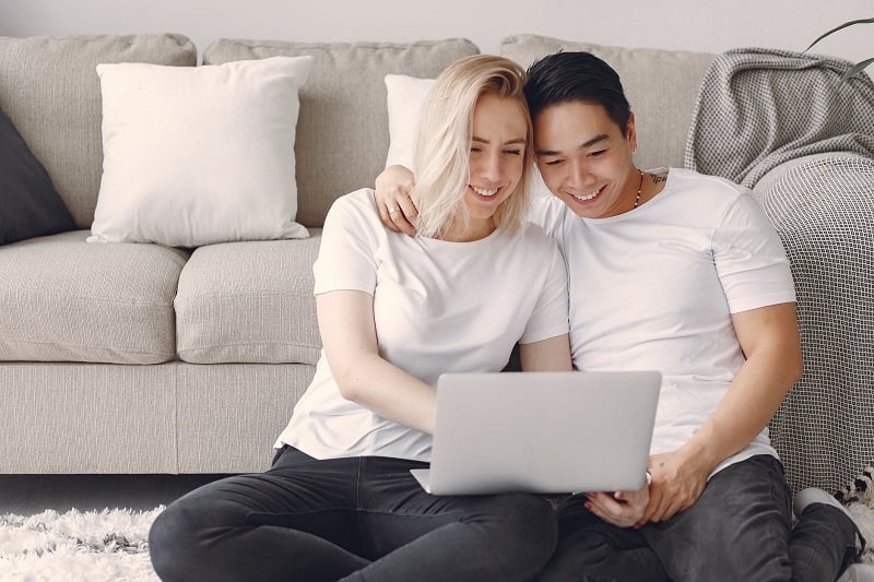 A couple watching musicals on a laptop.