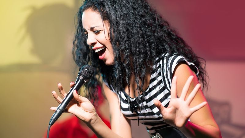 A woman singing with a microphone.