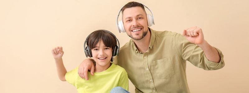 A father and son listening to headphones.