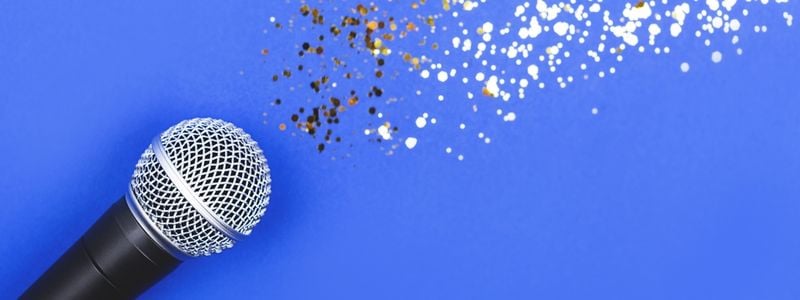 A microphone on a blue background with glitter.