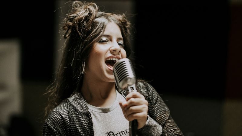 A woman singing into a microphone.