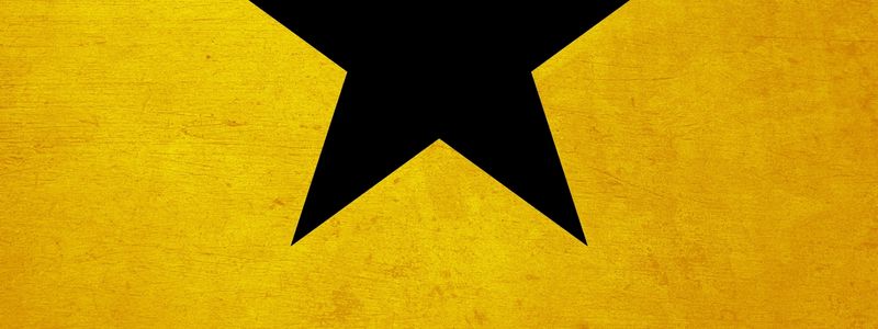 Yellow background with a cut off black star.