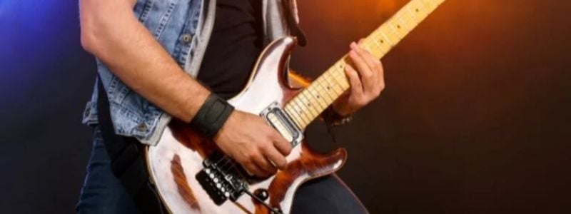 Hands playing an electric guitar.