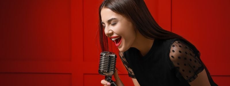 A woman belting into a microphone.