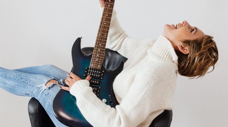 A woman playing the guitar.