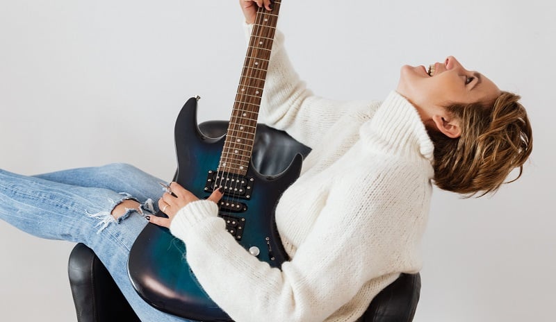 A woman playing the guitar.