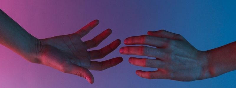 Two hands reaching out to each other.
