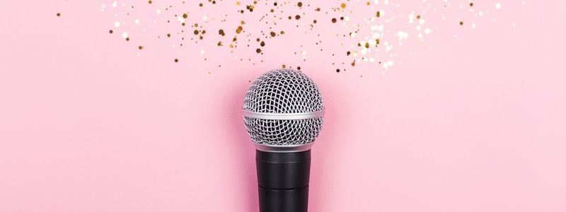 A microphone with glitter and a pink background.
