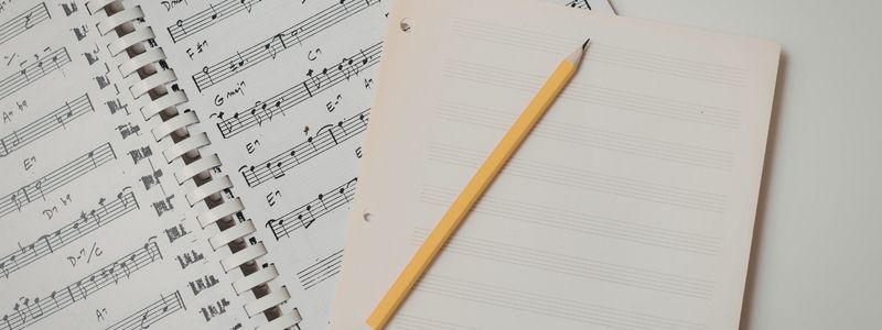 A pencil on top of sheet music.