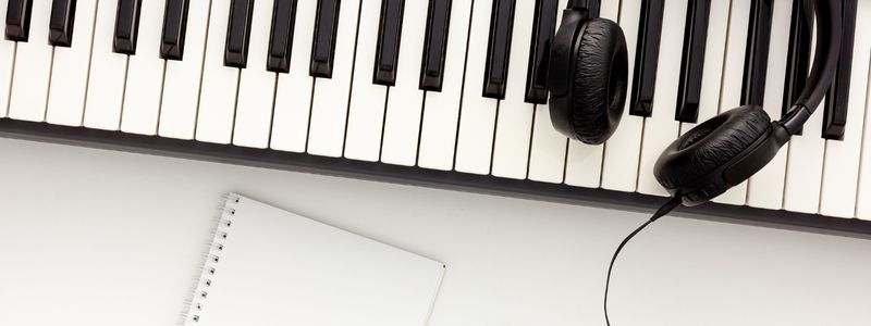 Piano keys, headphones, and blank paper.