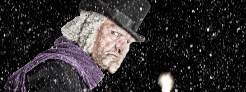 Scrooge holding a candle.