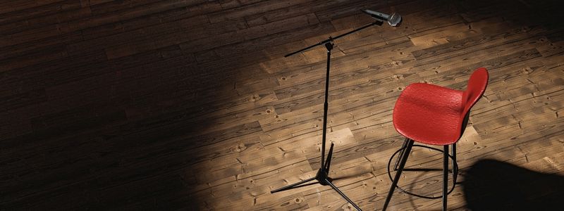 A chair and a microphone on a stage.