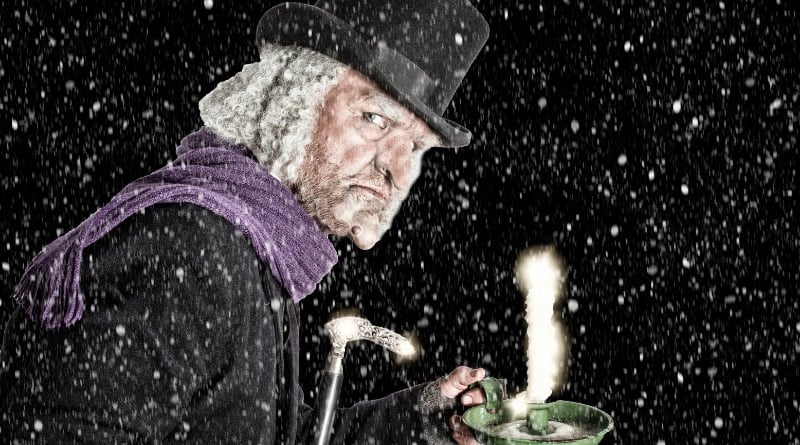 Scrooge holding a candle.