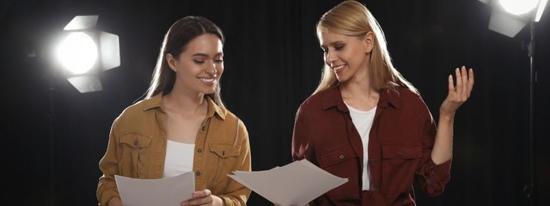 Two women rehearsing on stage.