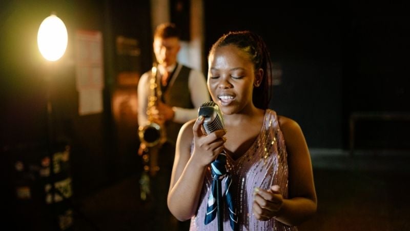 A woman singing a soul song with a saxophonist.