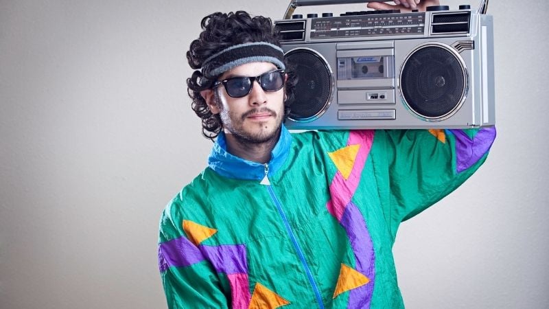 A man from the 1990s holding a boom box.