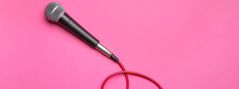 A microphone on a pink background.