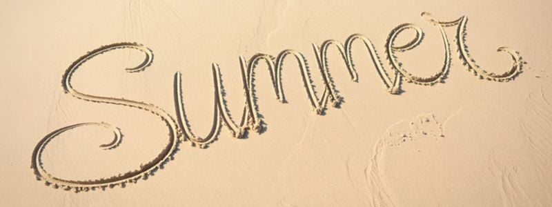 The word "summer" written in the sand.