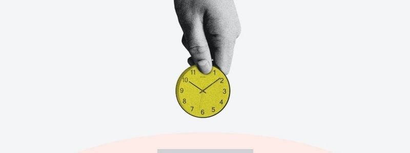 A hand holding a mini clock.