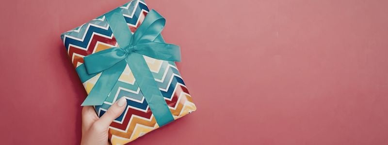 A colorfully wrapped gift with teal ribbon.