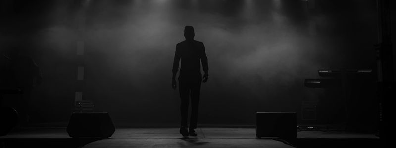 The shadow of a man on a dark stage.